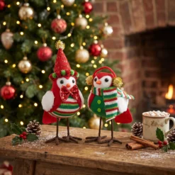 Classic red and green Christmas felt bird figurines in a cozy fireplace scene